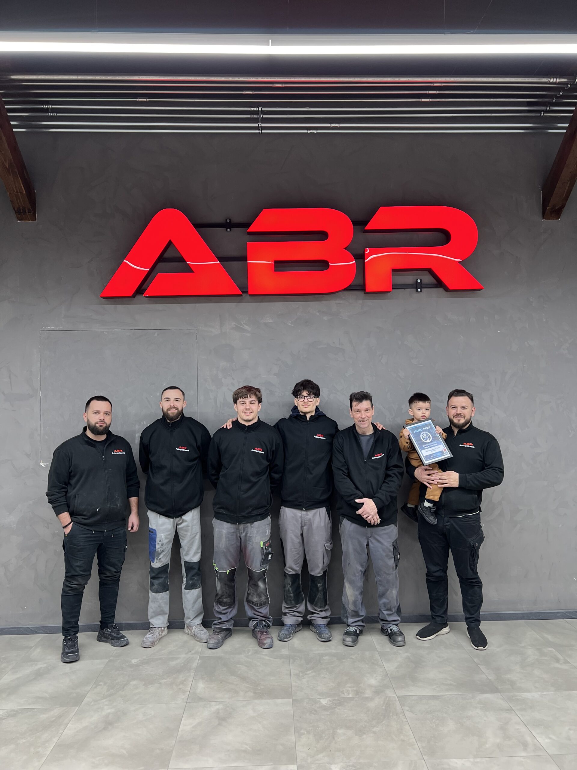 Das ABR Autospritzwerk-Team mit Gold Partner-Urkunde von Polizei.news (Bild: © Philipp Ochsner)