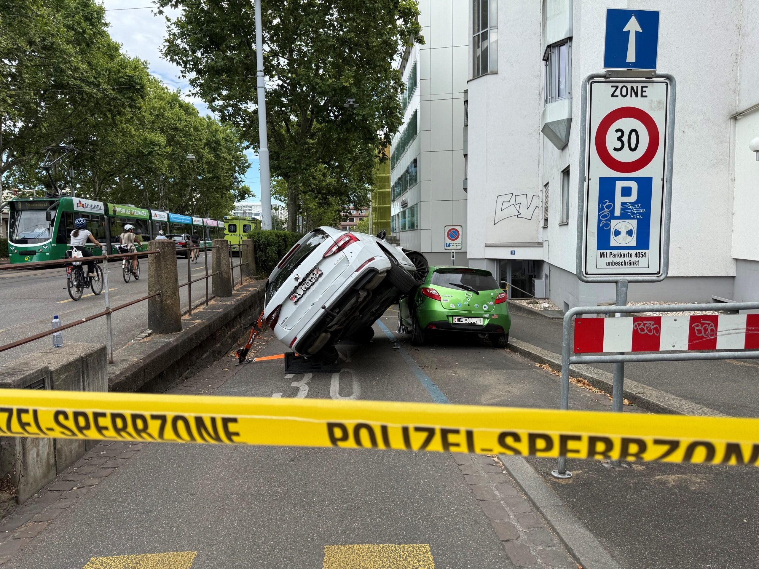 Basel-BS-Auto-kippt-nach-Kollision-mit-parkiertem-Fahrzeug-auf-zwei-R-der